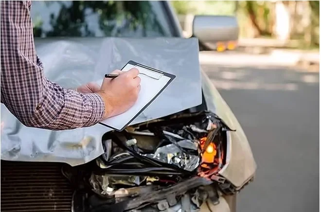 Engenheiro registrando os danos na frente de um veículo acidentado