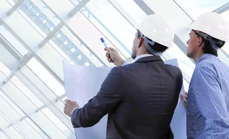 Engenheiros analisando documentos técnicos em uma instalação
